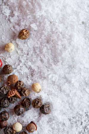 Composition of bay laurel leaf with peppercorn and salt isolated on dark background, top view, close-up, selective focusの写真素材