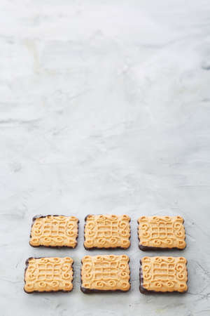 Square biscuits arranged in pattern on light textured background, close-up, shallow depth of field,...