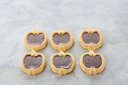 Apple shaped biscuits arranged in rows on light textured background, close-up, shallow depth of field, selective focus.の写真素材