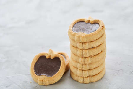 Apple shaped biscuits arranged in rows on light textured background, close-up, shallow depth of field, selective focus.の写真素材