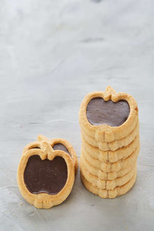 Apple shaped biscuits arranged in rows on light textured background, close-up, shallow depth of field, selective focus.の写真素材