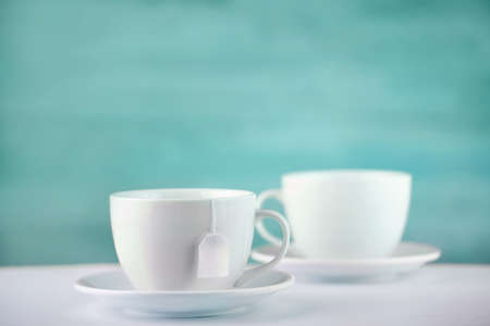 Two white porcelain teacups on white table show clean and simple design ideas, selective focusの写真素材