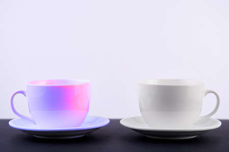 Two white porcelain teacups on black table show clean and simple design ideas, selective focusの写真素材