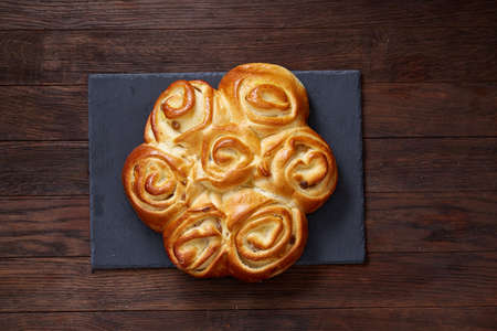 Homemade rose bread on black cutting board on vintage background, close-up, shallow depth of fieldの写真素材