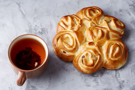 Homemade rose bread, cup of tea, dried citrus and spicies on white textured background, close-up, shallow depth of fieldの写真素材