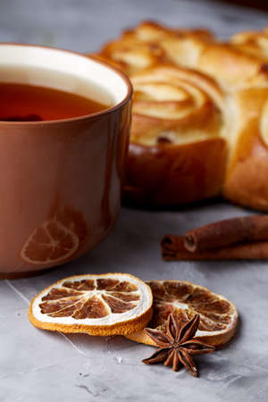 Homemade rose bread, cup of tea, dried citrus and spicies on white textured background, close-up, shallow depth of fieldの写真素材