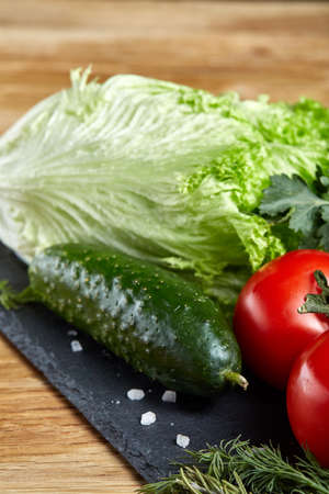 Organic closeup still life of assorted fresh vegetables and herbs on rustic wooden background, topview, selective focus.の写真素材