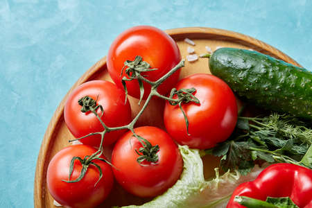 Refreshing close-up still life of assorted fresh vegetables and herbs on blue background, top view, selective focus.の写真素材