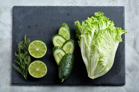 Concept of fresh green lettuce, cucumber, dill, lime on a light background, selective focus, top view, copy space.の写真素材