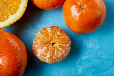 Variety of fresh citrus fruits for making juice or smoothie over blue textured background, top view, selective focus.の写真素材
