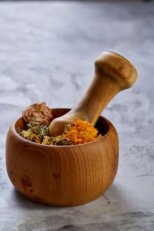 Spa still life with flowers in wooden bowl on light textured background, top view, close-up, selective focus. Alternative medicine. Spa natural concept. Dayspa cosmetics products. Spa and wellness setting. Spa decoration concept.の写真素材