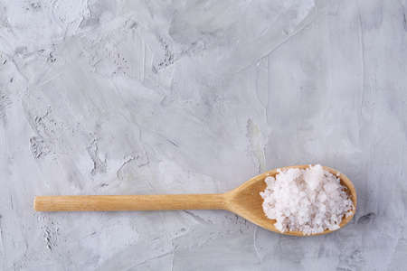 Conceptual composition of salt and pepper on spoons and bowls over light background, top view, close-up. Aromatic and organic condiment. Organic flavour. Cuisine culture. Food background.の写真素材