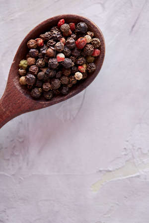 Conceptual composition of salt and pepper on spoons and bowls over light background, top view, close-upの写真素材