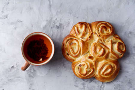 Homemade rose bread, cup of tea, dried citrus and spicies on white textured background, close-up, shallow depth of fieldの写真素材