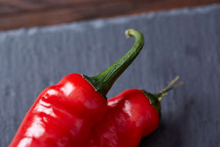Vegetarian still life with fresh grape tomatoes, pepper and salt in wooden spoon on wooden background, selective focusの写真素材