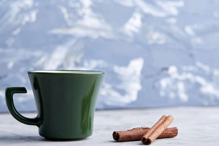 Cup of creamy coffee with cinnamon and star anise on a white textured background, top view, close-up, selective focusの写真素材