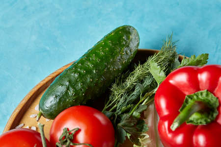 Refreshing close-up still life of assorted fresh vegetables and herbs on blue background, top view, selective focus.の写真素材
