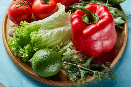 Refreshing close-up still life of assorted fresh vegetables and herbs on blue background, top view, selective focus.の写真素材