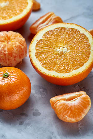 Variety of fresh citrus fruits for making juice or smoothie over light textured background, top...