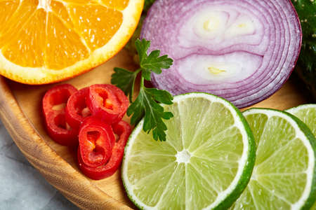 Still life of fresh organic vegetables on wooden plate over white background, selective focus, close-upの写真素材