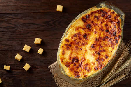 Traditional Italian lasagna cooked in a glass pan over vintage wooden background, top view, close-up, selective focusの写真素材