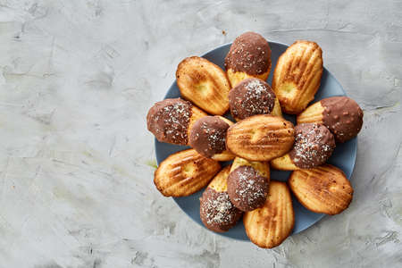 Freshly baked almond cookies piled on ceramic plate over white background, top view, close-up, selective focusの写真素材