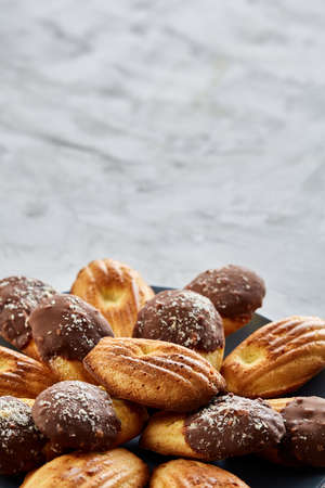 Freshly baked almond cookies piled on ceramic plate over white background, top view, close-up, selective focusの写真素材