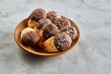 Freshly baked almond cookies piled on ceramic plate over white background, top view, close-up, selective focusの写真素材