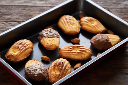 Freshly baked almond cookies on cooking tray over wooden background, top view, selective focus.の写真素材