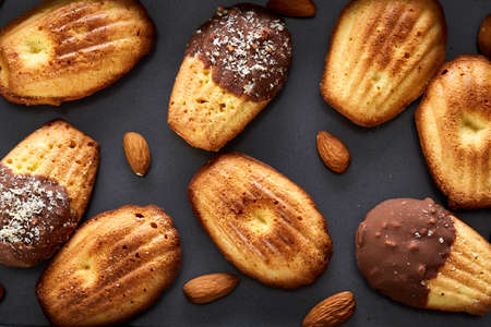 Freshly baked almond cookies on cooking tray over wooden background, top view, selective focus.の写真素材