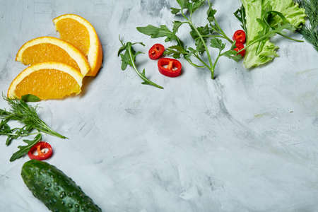 Fresh vegetables still life. Cucumber, tomato, onion, lemon, lime and lettuce lined up on a white background, top view, close-up, selective focus, copyspace. Studioshot. Creative composition. Preparation for cooking. Healthy lifestyle concept.の写真素材