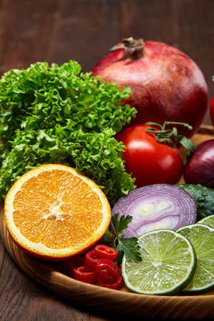 Bowl with oatmeal flakes served with kiwi, lime, lemon, orange, tangerin, apple and pomergranate on wooden tray wooden background, flat lay, selective focus. Healthy breakfast concept. Nutritious and diet snack.の写真素材