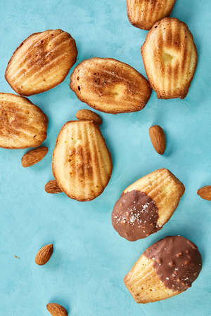 Delicious almond cookies messy arranged together with almond on blue background, close-up, selective...