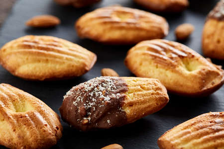 Freshly baked almond cookies on stone board over vintage wooden background, top view, selective...