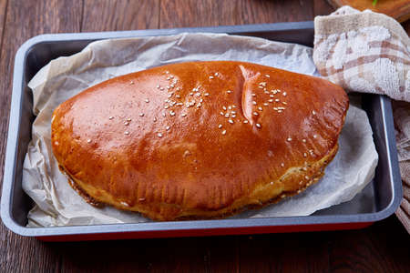 Tasy cottage cobbler with herbs and vegetables on a cooking tray over a wooden background, selective focus. Countryside still life. Yummy puffy meal. Tasty cobbler. Homemade appetizer.の写真素材