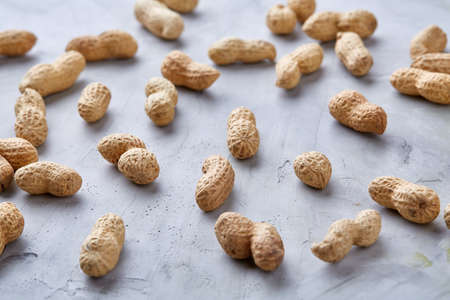Seamless pattern shelled peanuts isolated on white textured background, top view, close-up, selective focus, shallow depth of field. Healthful and nutritious snack. Delicious ingredient for your every day cooking. Healthy lifestyle concept.の写真素材