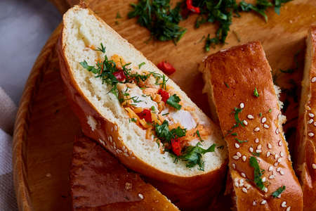 Countryside cuisine still life with tasty homemade pie, fresh mushrooms, hot pepper, garlic and herbs on wooden cutting board over white textured background, selective focus. Studio shot. Delicious rustic appetizer. Food concept.の写真素材