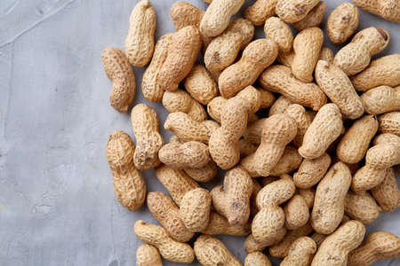 Seamless pattern shelled peanuts isolated on white textured background, top view, close-up, selective focus, shallow depth of field. Healthful and nutritious snack. Delicious ingredient for your every day cooking. Healthy lifestyle concept.の写真素材