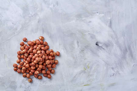 Raw hazelnut on heap isolated on white textured background, close-up, selective focus, shallow depth of field. Some copy space for your inscription. Nutritious organic snack. Vegetarian protein. Seasonal antioxidant. Healthy food concept.の写真素材