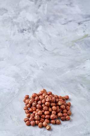 Raw hazelnut on heap isolated on white textured background, close-up, selective focus, shallow depth of field. Some copy space for your inscription. Nutritious organic snack. Vegetarian protein. Seasonal antioxidant. Healthy food concept.の写真素材