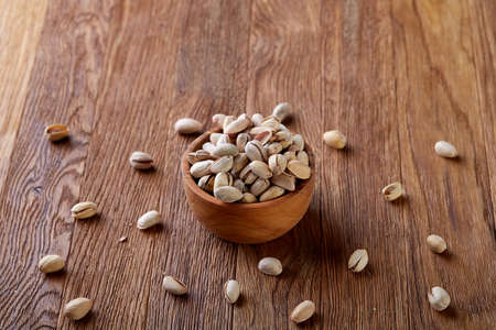 Almonds in brown bowl on rustic wooden background, top view, selective focus. Some copy space. Tasty organic snack. Healthy food for healthy life. Food concept. Natural nutritious nut. Delicious appetizer.の写真素材