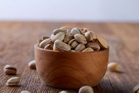 Almonds in brown bowl on rustic wooden background, top view, selective focus. Some copy space. Tasty organic snack. Healthy food for healthy life. Food concept. Natural nutritious nut. Delicious appetizer.の写真素材