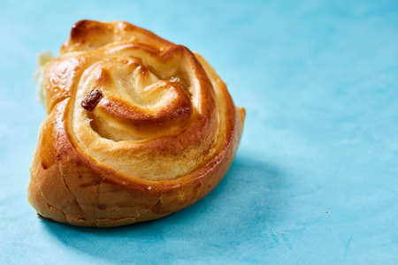 Fresh and tasty submarine sandwich with cheese and vegetables on cutting board over light blue background, selective focus. Nutritious crusty snack. Yummy fast food. American cuisine. Food background.の写真素材