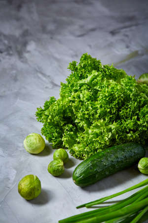 Fresh vegetables still life over white textured background, close-up, flat lay. Assortment of fresh vegetables with squash, brussel sprout, letucce, green onion and dill. Colorful vegetables background. Healthy vegetable studio photo. Food concept.の写真素材
