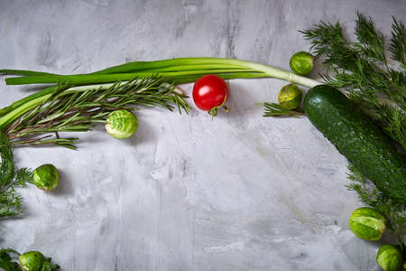 The round frame made of vegetables and herbs on a white textured background, copy space, top view, close-up. Artistic studio shot. Fresh veggies assortment. Greengrocery diversity. Healthy food concept.の写真素材