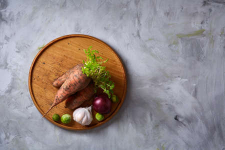 Colorful various of organic farm vegetables with fresh carrots, garlic, onion, brussel sprout on...