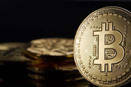 Conceptual image of crypto currency with isolated bitcoins on dark table. Focus of coins. Other in gradient blur. Dark background. Selective focus, front focus, shallow depth of field. Cryptocurrency concept.の写真素材