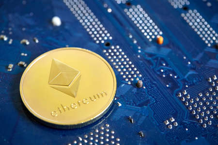 Golden ethereum coin cryptocurrency on a computer mainboard, selective focus, shallow depth of...