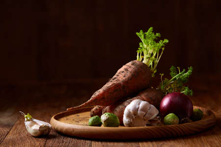 Colorful various of organic farm vegetables with fresh carrots, garlic, onion, brussel sprout on...