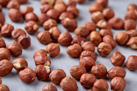 Raw hazelnut on heap isolated on white textured background, close-up, selective focus, shallow depth...